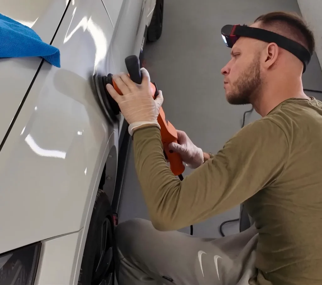 Person polishing a car's surface.