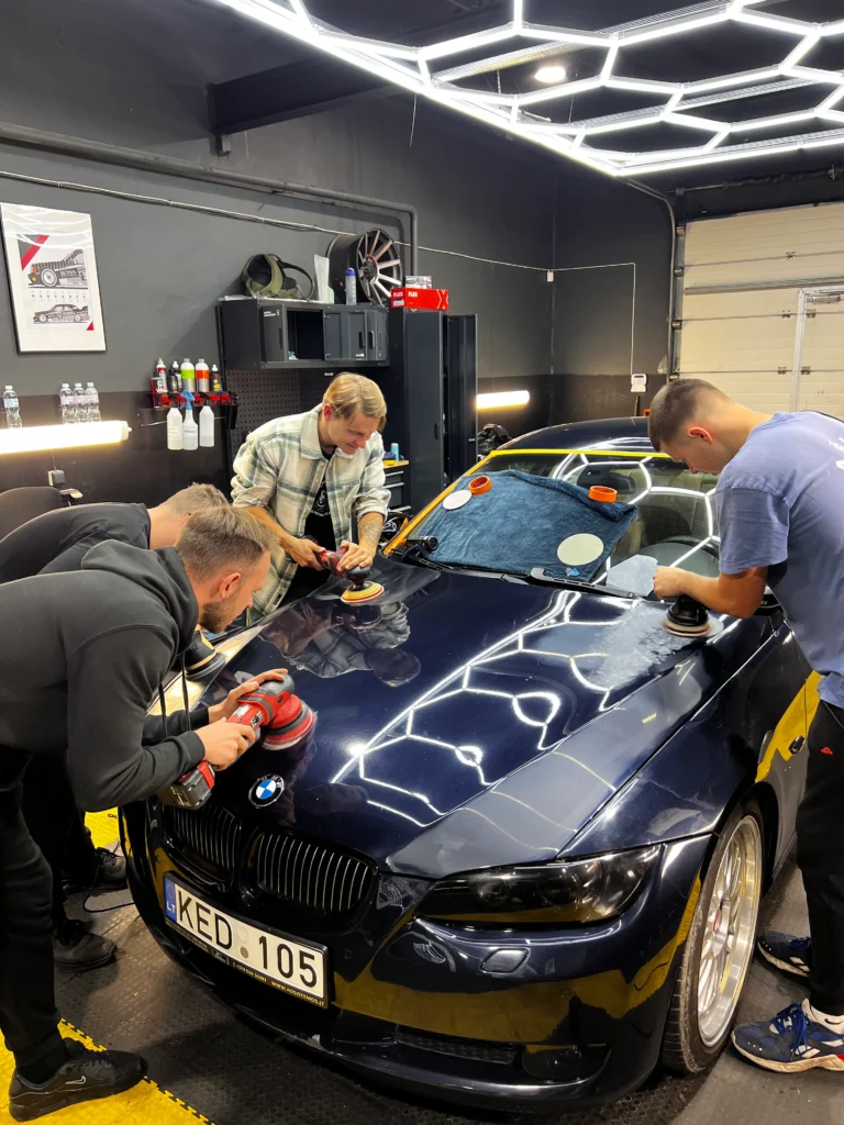 Detailers in studio polishing car with the best detailing products